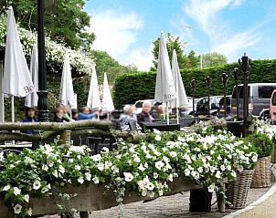 Gezellig terras in Oostkapelle, nabij VZ069 Vakantieappartement, Walcheren, met bloeiende bloemen.