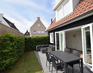 Zijaanzicht van VZ1078 Vakantiehuis in Oostkapelle met ruime tuin en zitgedeelte.