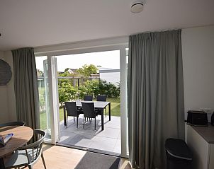 Uitzicht vanuit de woonkamer van VZ1078 Vakantiehuis in Oostkapelle naar de tuin.