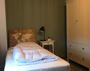 Slaapkamer in VZ1162 Vakantiehuis in Oostkapelle, Walcheren met wereldkaart hoofdbord.