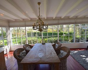 Sfeervolle eethoek met uitzicht op tuin in VZ2316 Vrijstaand vakantiehuis in Oostkapelle, Walcheren, Zeeland.