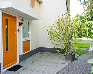 Front door of vacation home ZE1402 in Oostkapelle, Walcheren, Zeeland with striking orange color.