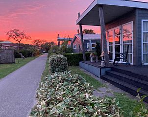 Gezellige slaapkamer in ZE1593 vakantiehuis Oostkapelle, Walcheren, met tweepersoonsbed en bloemen.