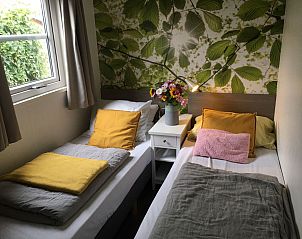 Zonnig terras met parasol bij ZE1593 vakantiehuis in Oostkapelle, Walcheren, Zeeland.