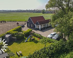 Vogelhuisje in de tuin van vakantiehuis ZE187, Oostkapelle, Walcheren, omgeven door groen.