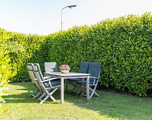 Tuin met zitgelegenheid bij vakantiehuis ZE187, Oostkapelle, Walcheren, ideaal voor buitenmaaltijden.