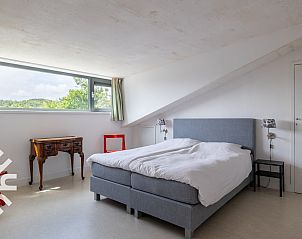 Cozy sitting area in vacation home ZE263, Westkapelle with wood stove and large windows.