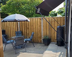 Sonnige Terrasse mit Sonnenschirm am Ferienhaus VZ2343 Westkapelle, ideal zum Entspannen.