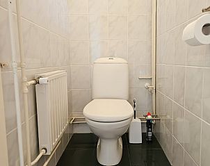 Moderne badkamer in Vakantiehuis in Westkapelle met toilet en tegelwanden, Walcheren, Zeeland.