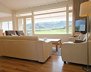 Woonkamer in Vakantiehuis in Westkapelle met uitzicht op groene heuvels, Walcheren, Zeeland.