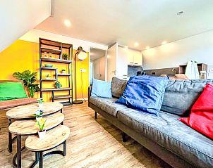 Gezellige woonkamer in Appartement Beach House Westkapelle 107.6, Westkapelle, Zeeland met kleurrijke kussens en moderne inrichting.