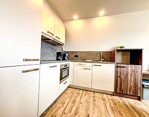 Moderne keuken in Appartement Beach House Westkapelle 107.6, Westkapelle, Zeeland met strakke witte kasten en alle gemakken.