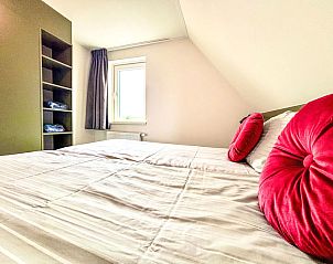 Sfeervolle slaapkamer in Appartement Beach House Westkapelle 107.6, Westkapelle met comfortabel bed en warme kleuren.