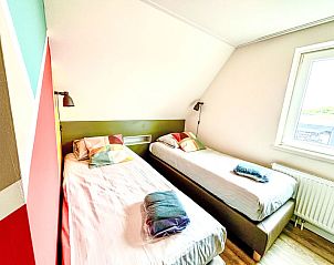 Tweede slaapkamer met uitzicht in Appartement Beach House Westkapelle 107.6, Westkapelle, ideaal voor gezinnen.