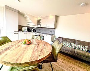 Esszimmer und Kche im Ferienhaus Beach House Westkapelle 103 D, Westkapelle, Walcheren, mit rundem Holztisch.