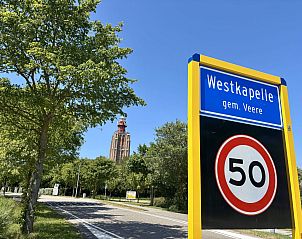 Eingang zur Westkapelle bei Holiday Home Beach House Westkapelle 103 D, mit Straenschild und Leuchtturm im Hintergrund.