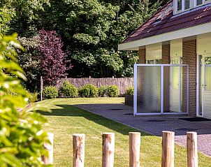 Der grne Garten des Ferienhauses ZE014 in Domburg, Walcheren, ist von Bumen umgeben und sorgt fr ein ruhiges Outdoor-Erlebnis.