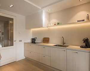 Moderne keuken in Champagne Wellness 6 vakantiehuis in Domburg, Walcheren met strakke afwerking.