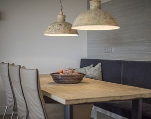 Gezellige eethoek in Champagne Wellness 6 appartement in Domburg met houten tafel en sfeervolle lampen.