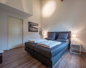 Moderne badkamer in Comfort 5A bungalow, Domburg Walcheren Zeeland, met strakke witte tegels en luxe voorzieningen.