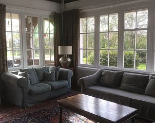 Zonnige zithoek in Villa Vacuna, vakantiehuis in Domburg, Walcheren met uitzicht op de tuin.