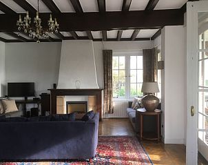 Stijlvolle woonkamer met houten balken in Villa Vacuna, vakantiehuis in Domburg, Walcheren.