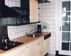Moderne keuken in Villa Vacuna, vakantiehuis in Domburg, Walcheren met zwart-wit tegelvloer.