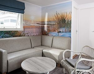 Gezellige zithoek in SCR chalet, Domburg, Walcheren, met strandthema en comfortabele meubels voor een ontspannen vakantie in Zeeland.