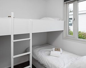 Gezellige slaapkamer in SCR chalet, Domburg, Walcheren met stapelbed en uitzicht op natuur in Zeeland.