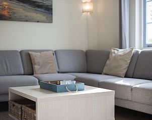 Gemtliches Wohnzimmer des T6 Comfort Bungalows in Domburg, Walcheren, Zeeland, mit bequemen Sofas und stimmungsvoller Beleuchtung.