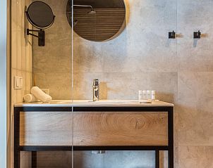 Elegante badkamer in VZ913 Junior Suite te Vlissingen, Walcheren, Zeeland met houten wastafel en spiegel.