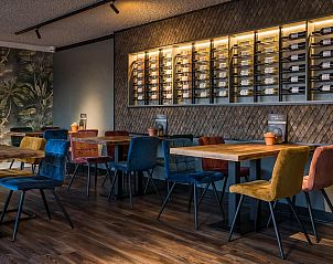 Stijlvolle eetruimte in VZ913 Junior Suite te Vlissingen, Walcheren, Zeeland met kleurrijke stoelen.