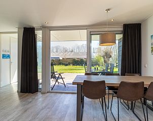 Pittoreske molen nabij vakantiehuis ZE1446 in Aagtekerke, Walcheren, omgeven door bloemen.