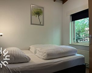 Bequemes Sofa im Wohnzimmer des Ferienhauses ZE312 in Zoutelande, Walcheren mit Blick auf den Garten in Zeeland.