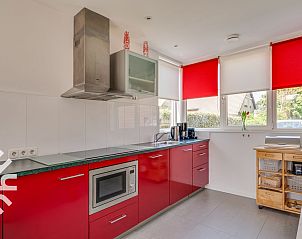 Knusse zithoek op het terras van vakantiehuis ZE1135 in Zoutelande, Walcheren, met wijn en bloemen.