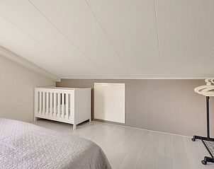 Slaapkamer met babybedje in Vakantiehuisje in Zoutelande, Walcheren, ideaal voor gezinnen.