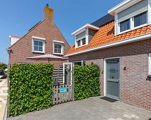 Sunny terrace with dining table at vacation home ZE1323 in Zoutelande, Walcheren for outdoor fun.