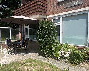Gezellig terras bij vakantiehuis ZE301 in Zoutelande, Walcheren, met parasol en tuinmeubilair.