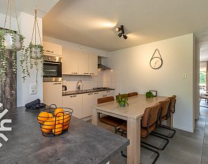 Ingang van vakantiehuis ZE1422 in Zoutelande, Walcheren, met houten poort en bloemen.