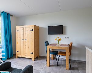 Cozy indoor area of vacation home ZE583 in Vrouwenpolder, Walcheren with a dining table and television in Zeeland.