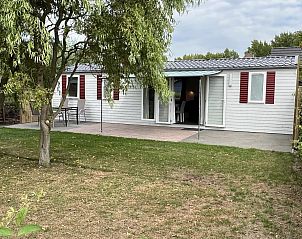 Achtertuin van VZ030 Chalet Vrouwenpolder, omgeven door groen in Walcheren, Zeeland