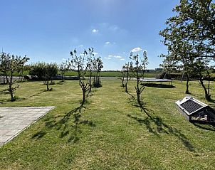 Ruime tuin met bomen bij VZ587 Vakantiewoning Vrouwenpolder, Walcheren, Zeeland.