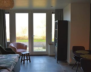Bright living room in Holiday home in Vrouwenpolder, Walcheren, Zeeland with large windows to terrace.