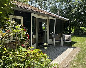 Outdoor dining area of vacation home ZE120, Veere, Walcheren under trees.