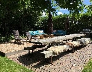 Gezellig terras bij Mariekerke vakantiehuis in Meliskerke, Walcheren, met ruime zitplaatsen en groene omgeving.