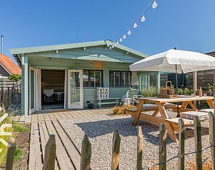Veranda van vakantiehuis ZE1468 in Meliskerke, Walcheren, met houten picknicktafel en parasol.