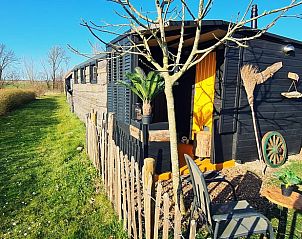 Charmante ingang van Vakantiehuis in Middelburg, Walcheren, Zeeland met houten hek en groene omgeving.