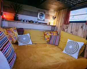 Knusse zithoek in Vakantiehuis in Middelburg, Walcheren, Zeeland met kleurrijke kussens en gezellige sfeer.