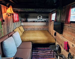 Zonnige buitenruimte bij Vakantiehuis in Middelburg, Walcheren, Zeeland met zitplaatsen en decoratieve elementen.