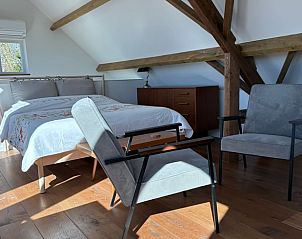 Comfortabele slaapkamer in Huisje in Middelburg, vakantieaccommodatie in Walcheren, Zeeland met houten vloer.